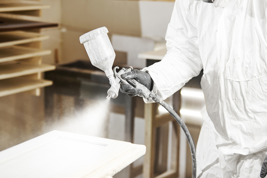 Close-up-of-industrial-worker-using-paint-gun-or-spray-gun-for-applying-paint,-airless-spraying.-130… 